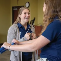 A woman conducting an evaluation on another woman during a physical therapy training.